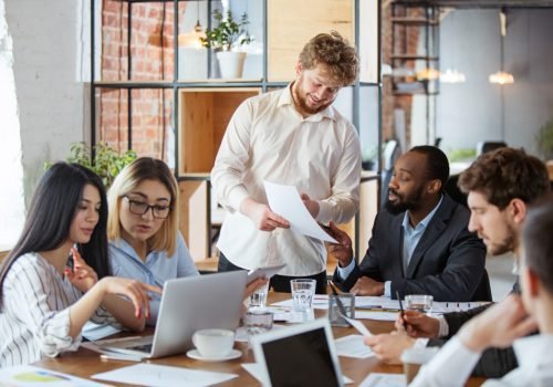 diverse-group-of-co-workers-having-casual-discussion-in-office