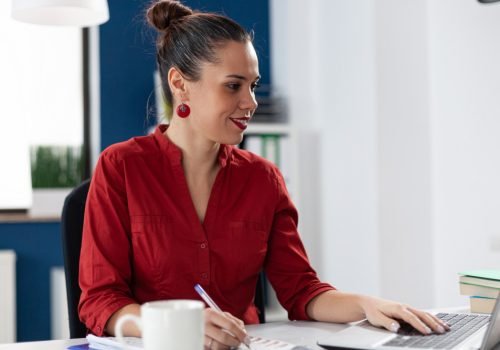 smiling-businesswoman-reading-data-from-laptop-screen